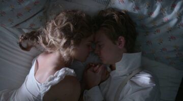 Scène uit de serie: The Artful Dodger. De twee hoofdrolspelers, Jack en Belle, liggen knuffelend op bed.