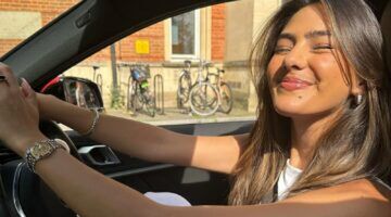 Foto van verslaggever Lissie Mackintosh, ze zit in haar auto en lacht.