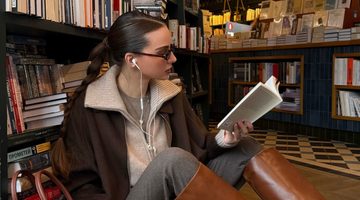 Meijse leest een boek in een bibliotheek