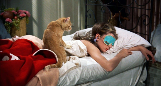 vrouw in bed met een slaapmasker
