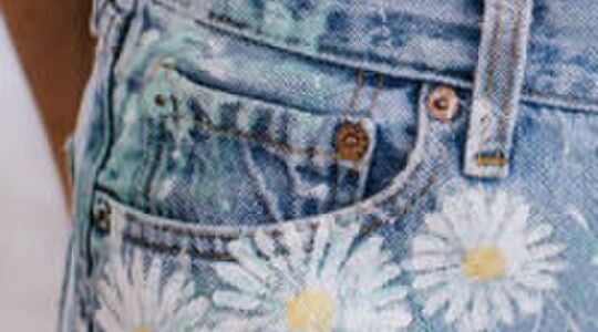 Illustratie voor: Hier zijn de metalen knopen op het kleine broekzakje van jeans voor