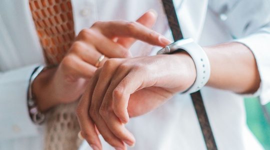 Vrouw kijkt op horloge.