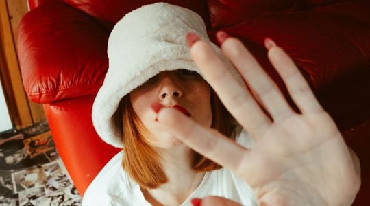 Vrouw drukt haar hand tegen de camera.