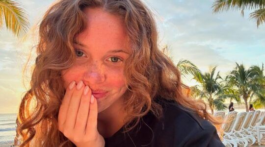 Meisje met krullen op het strand.