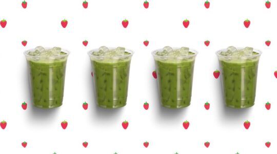 4 iced matcha's op een rijtje, op een aarbeien achtergrond.