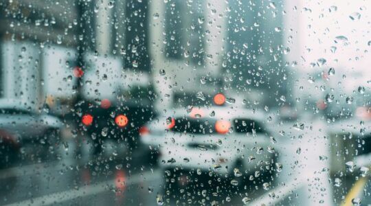 Een auto rijdt door de regen.