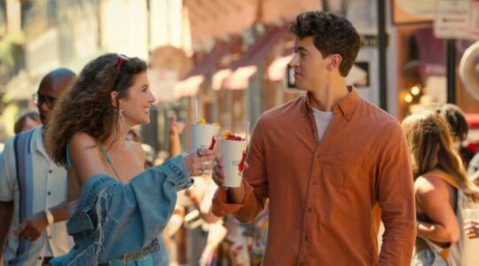 Jongen en meisje lopen samen door een straat en drinken een smoothie.