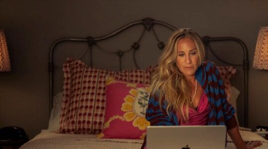Carrie Bradhsaw zit achter haar laptop op bed.