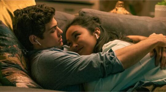 Peter en Lara-Jean knuffelen op de bank.