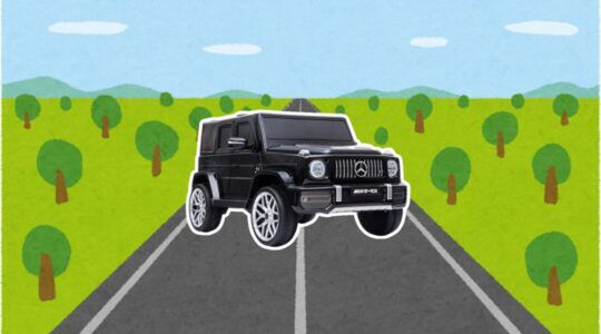 De elektrische kinderauto van de Action met een weg als achtergrond.