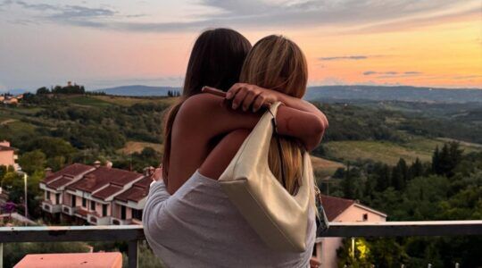 Twee meiden knuffelen met mooi uitzicht.