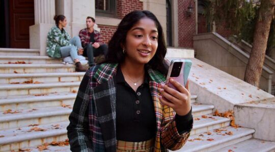 Devi kijkt op haar telefoon.