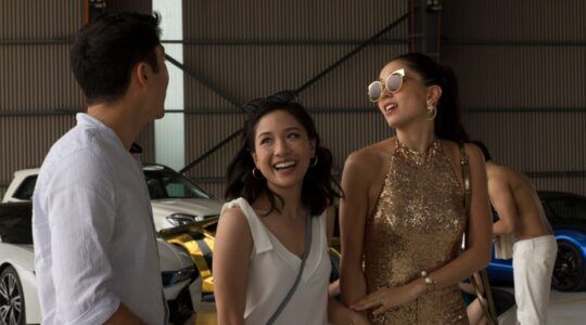 Drie rijke mensen lachen met elkaar.