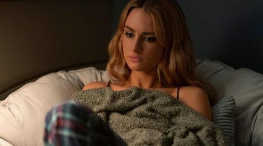 Lucy staart voor zich uit op bed.