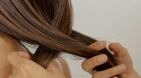 Het haar van een vrouw wordt gevlochten.