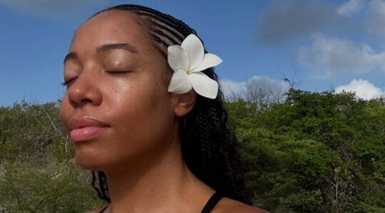 Meisje met bloem in haar gevlochten haar.