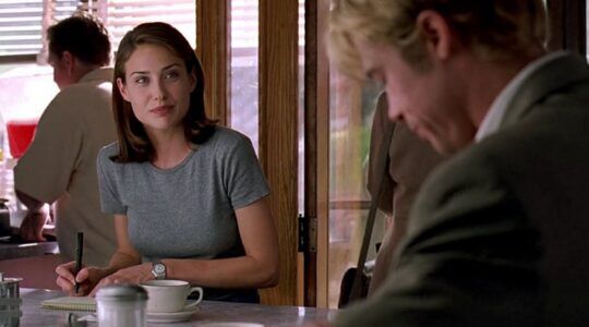 Scène uit Meet Joe Black. Meisje kijkt naar een jongeman die binnenkomt. Ze zit in een koffiezaakje.