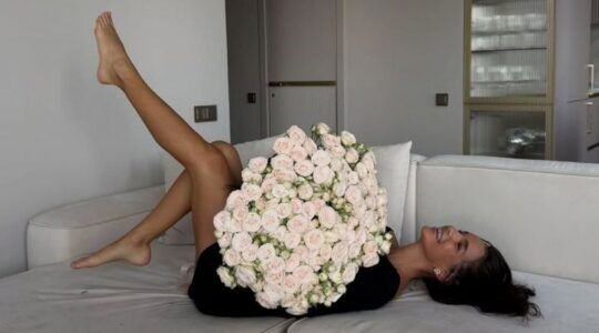 Meisje die met bloemen op een bank ligt.