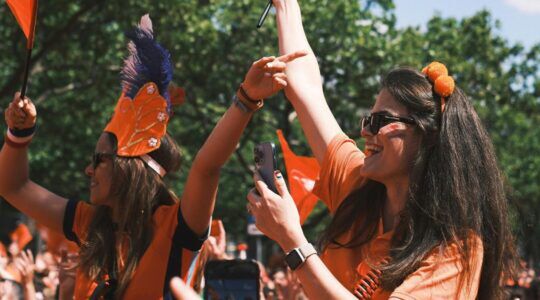 Twee vrouwen zijn aan het feesten tijdens Koningsdag.