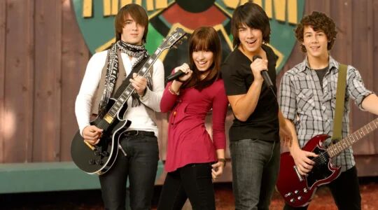 Demi Lovato, Kevin, Joe en Nicky Jonas met muziekinstrumenten