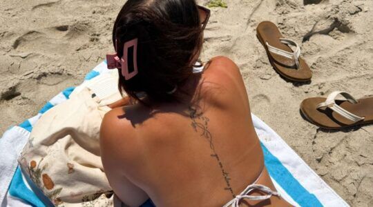 Meisje ligt te zonnen op het strand.