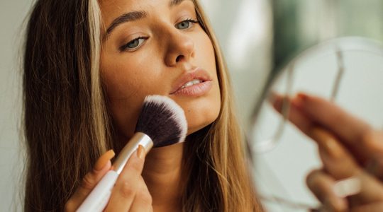 Vrouw brengt bronzer aan.