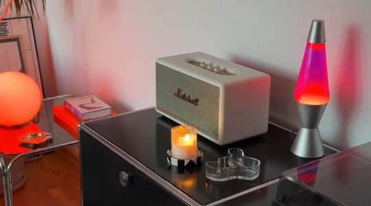 Een lavalamp, stereo en kaars op een kastje.
