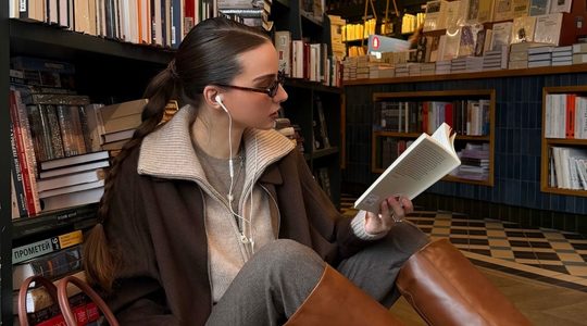 Meijse leest een boek in een bibliotheek