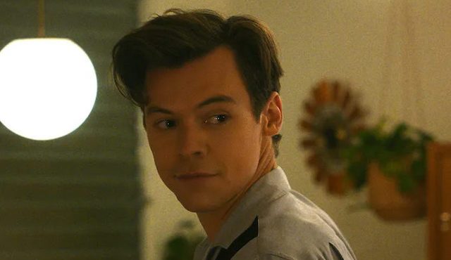 Harry Styles kijkt over zijn schouder.
