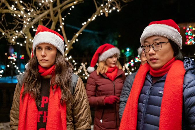 Twee mensen met een kerstmuts op kijken geirriteerd.