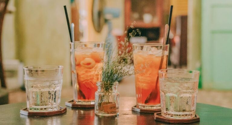 Vier cocktails op een tafel met garnering.