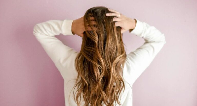 Vrouw gaat door haar haar met haar handen.