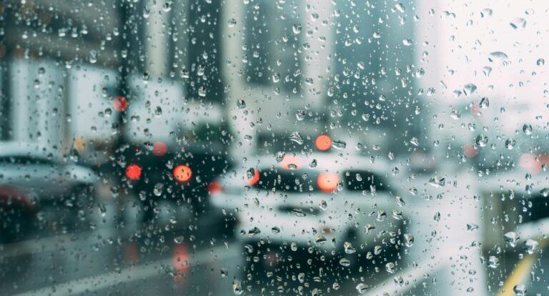 Een auto rijdt door de regen.