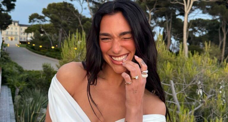 Dua Lipa lacht naar de camera.