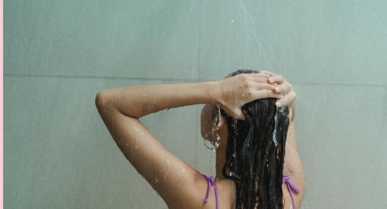 Meisje wast haar haren onder de douche.
