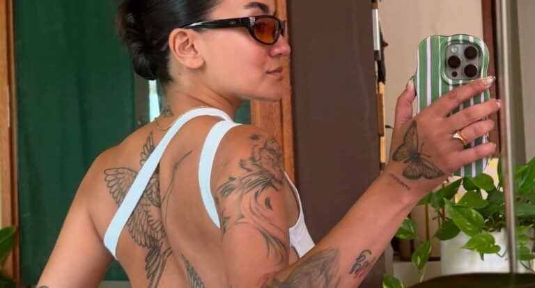 Meisje maakt een selfie in de spiegel van haar rugtattoos.