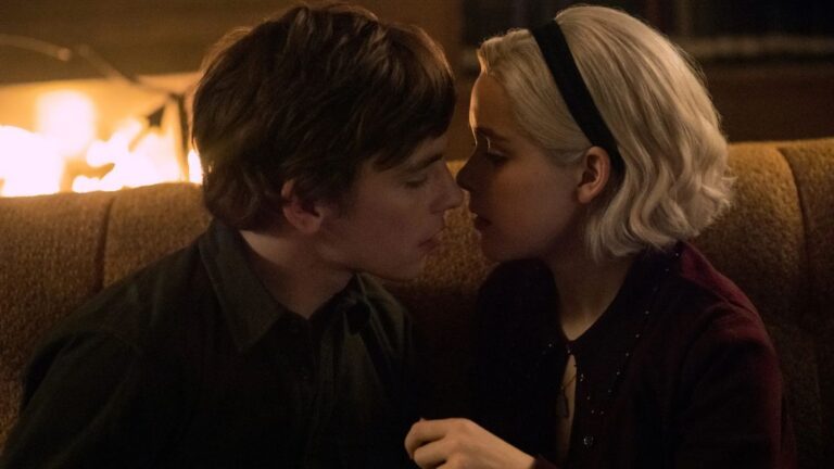 Harvey en Sabrina zoenen bijna voor de open haard in Chilling Adventures of Sabrina.