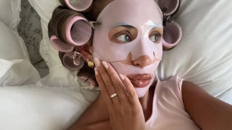 Meisje ligt met gezichtsmaskertje op in bed.