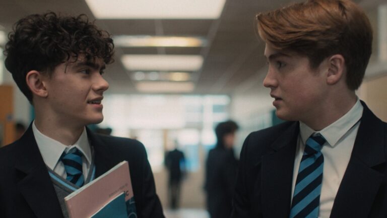 Twee jongens in schooluniform kijken elkaar aan.