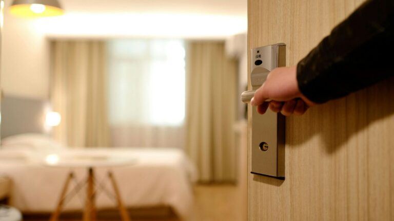 Iemand stapt een hotelkamer binnen.