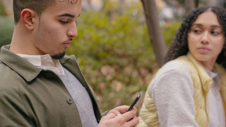 Man en vrouw hebben ruzie. Man kijkt op zijn telefoon tijdens de ruzie.