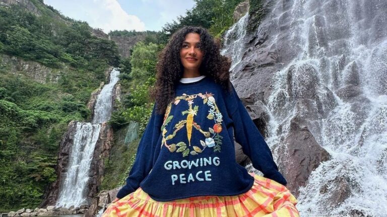 Olivia Dean poseert voor een foto voor een waterval.
