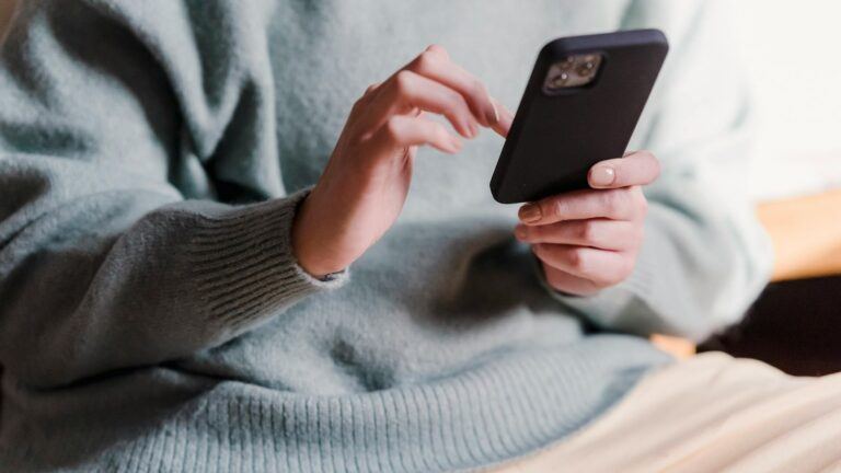 Iemand kijkt op haar telefoon.