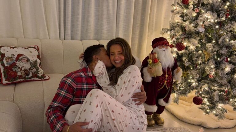Man en vrouw knuffelen samen voor de kerstboom.