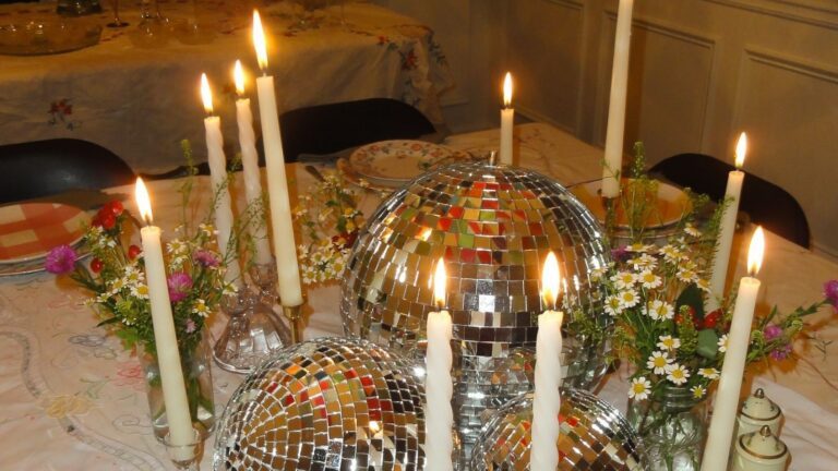 Gedekte tafel met kaarsen en discoballen.