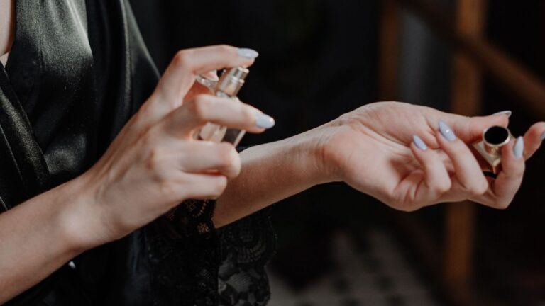 Vrouw spuit parfum op.