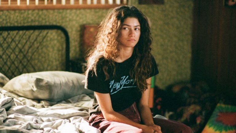 Rue van Euphoria zit op haar bed.