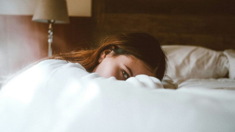 Meisje ligt op bed.
