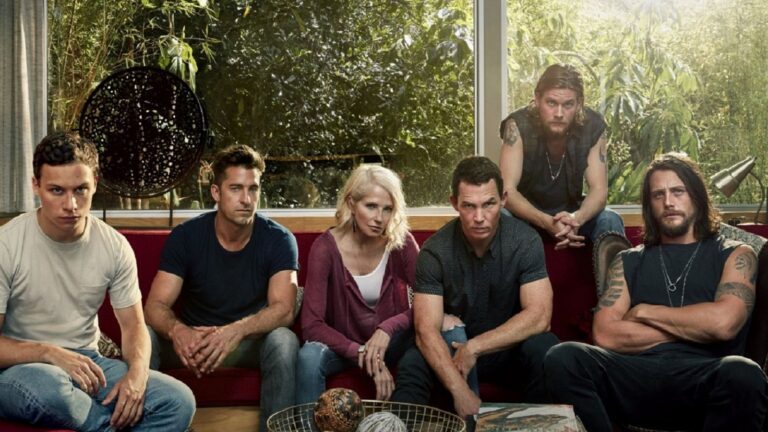 Sc&egrave;ne uit de serie Animal Kingdom. De familieleden zitten op een bank en kijken intens voor zich uit.