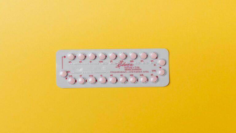 Anticonceptie pil met gele achtergrond.